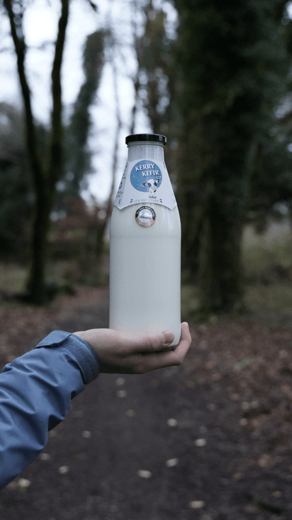 Person holding bottle of Kerry Kefir in one hand | Drinking Kefir