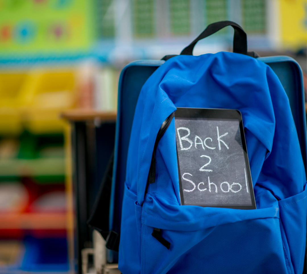 Child's school bag with back to school sign on it. Background in blurred out classroom